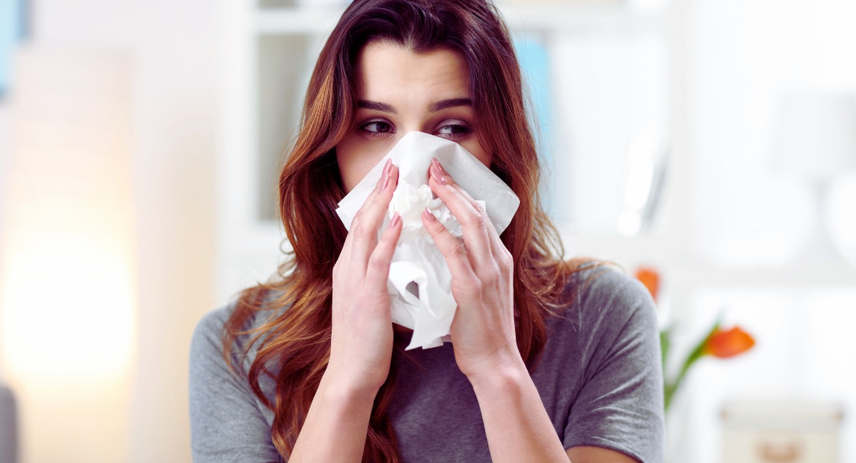 Femme se couvrant le nez avec un mouchoir en papier